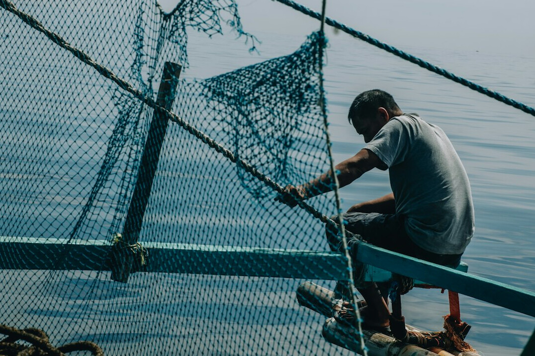 fisherman repairing nets