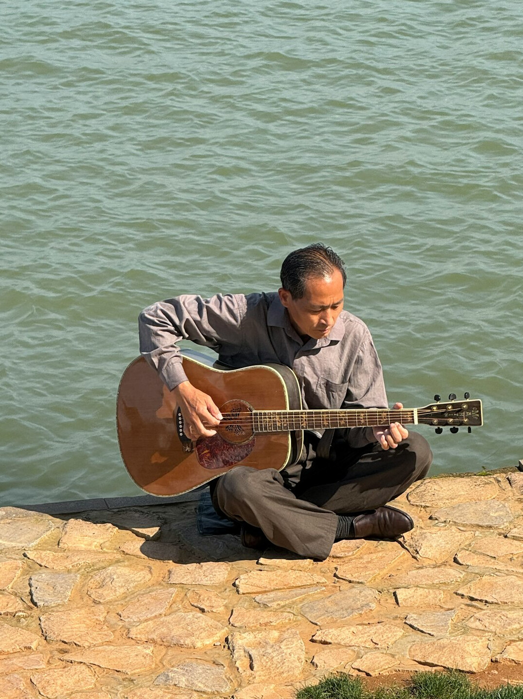 musician playing guitar outdoors